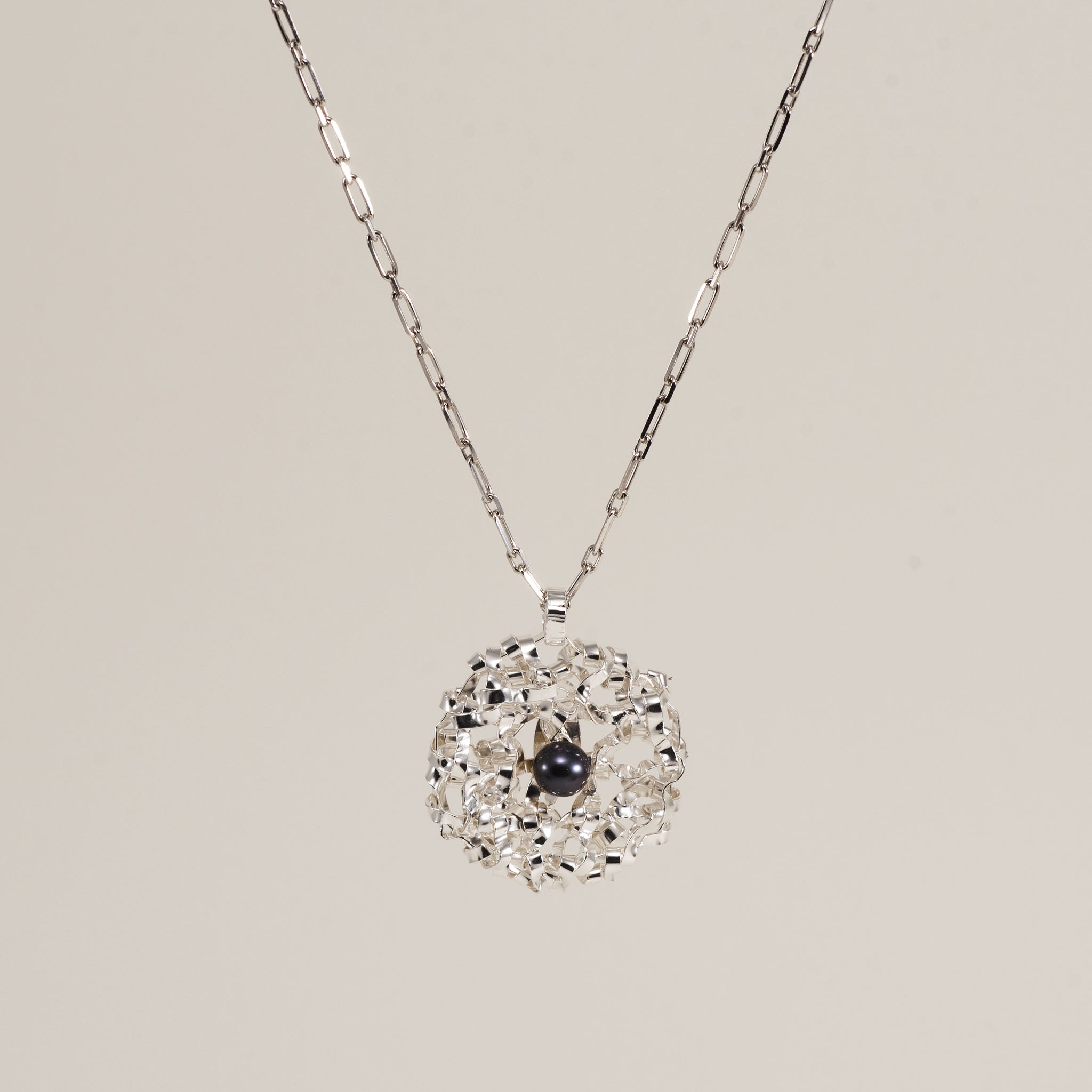 Collier pendentif rond tressé avec perle, fin et délicat.